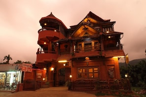 A large, ornate building with multiple balconies and a tower, likely a hotel or historic building. - Coffee Inn (Peermade)