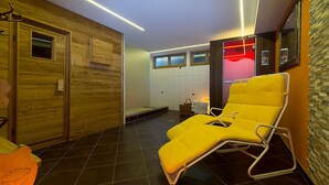 Un cuarto de spa con paredes de madera, un sillón reclinable amarillo y piso de baldosas.