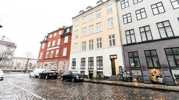 A row of colorful buildings with a cobblestone street in between.
