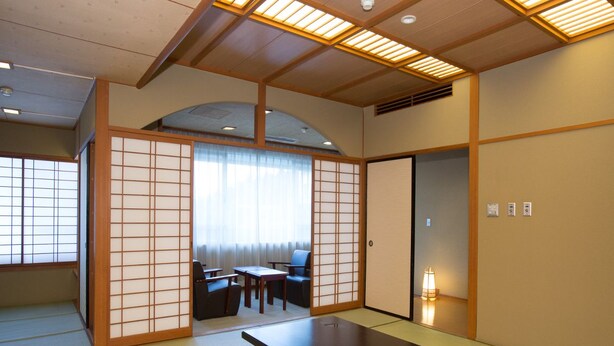 Ein traditioneller japanischer Raum mit Tatami-Böden, einem niedrigen Tisch und Schiebetüren.