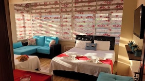Un dormitorio acogedor con cama, sofá y una mesita.