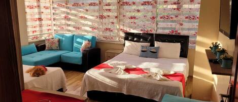 Un dormitorio acogedor con cama, sofá y una mesita.