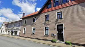 A building with a brown facade, multiple windows, and a red roof. - Altstadt Pension Orchidee (Wernigerode)