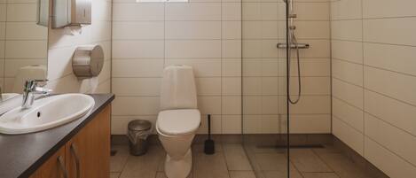 A bathroom with a sink, toilet, and shower.