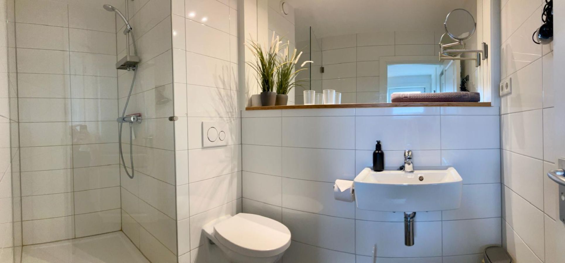 Un baño moderno con ducha, inodoro y lavamanos.