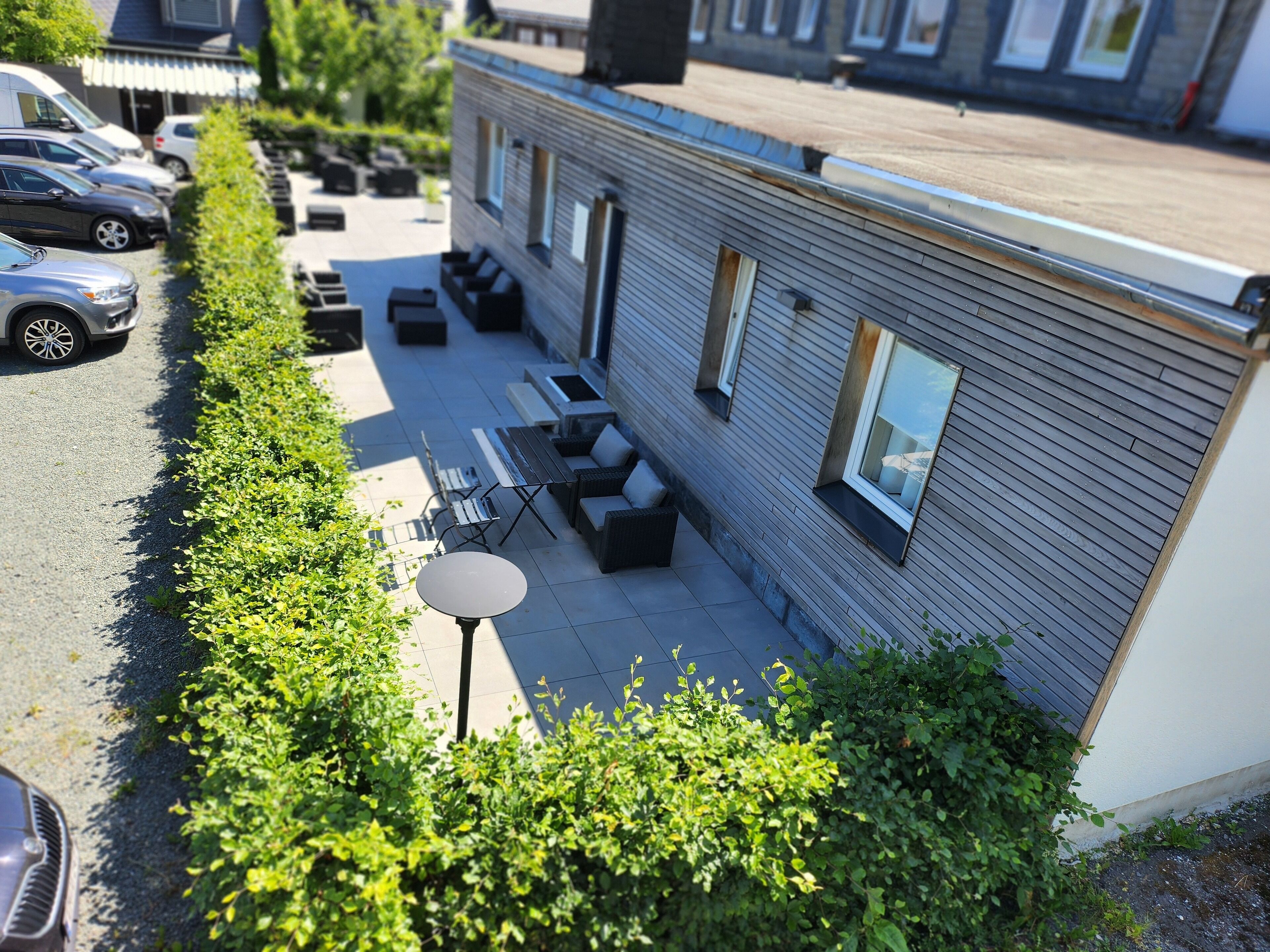 A modern building with a patio area featuring outdoor seating and a table.