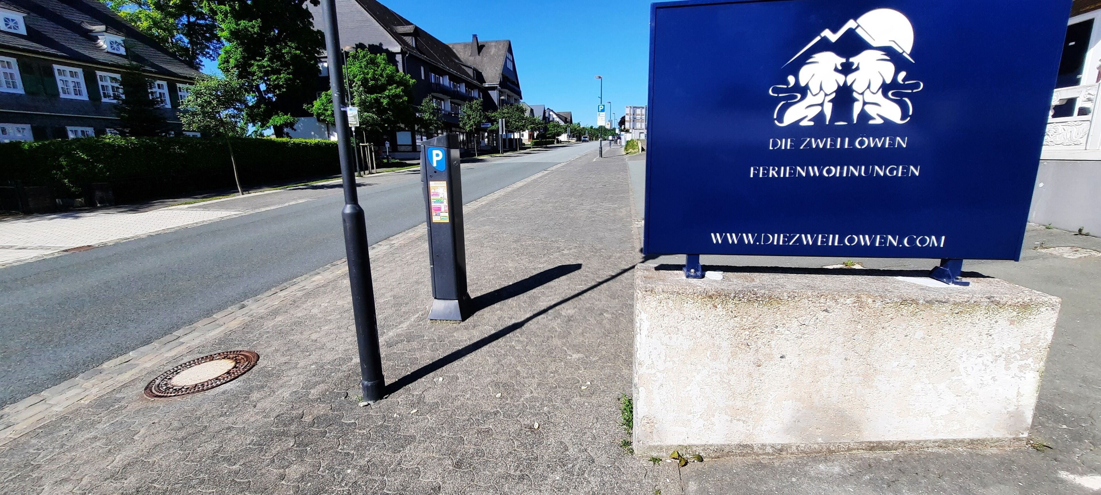 A sign for 'Die Zwillöwen Ferienwohnungen' with a website address.