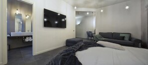 Relax in a spacious bedroom with a large bed, flat-screen TV, and cozy seating area.
