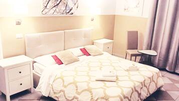 A hotel room with a bed, two bedside tables, a chair, and a small table.