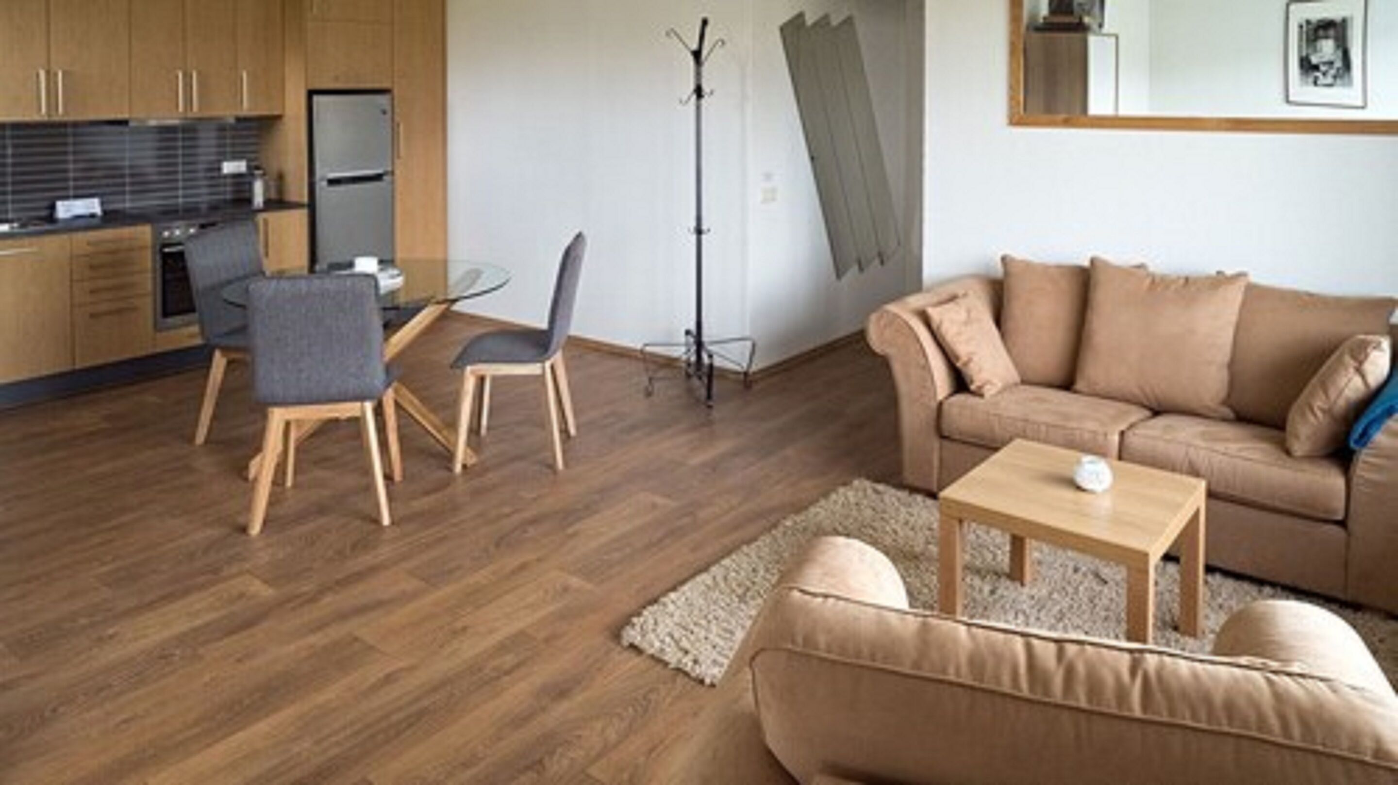 Una sala moderna con un sofá, una mesa de centro y un comedor con sillas y una mesa.