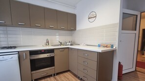 Una cocina moderna con electrodomésticos de acero inoxidable, lavavajillas y horno empotrado.