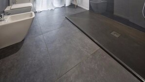 A modern bathroom with a bathtub, toilet, and shower area. - Suite Vogue Visconti (Voghera)