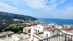 A coastal town with terraced houses, a beach, and a view of the sea. - B&B Villa Passiaturo (Peschici)