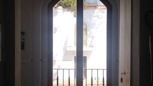Ein rundbogiger Durchgang führt zu einem Balkon mit Geländer.