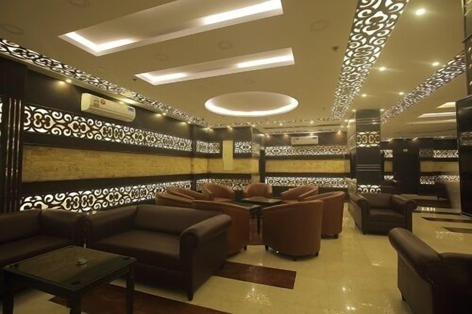 A modern lounge area with leather sofas, a coffee table, and a patterned wall.