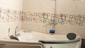Une salle de bain moderne avec une baignoire sur pieds, une douchette et un panneau de commande.