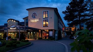A hotel with a modern design, featuring a circular logo and a covered entrance. - Vital Hotel Westfalen Therme (Bad Lippspringe)