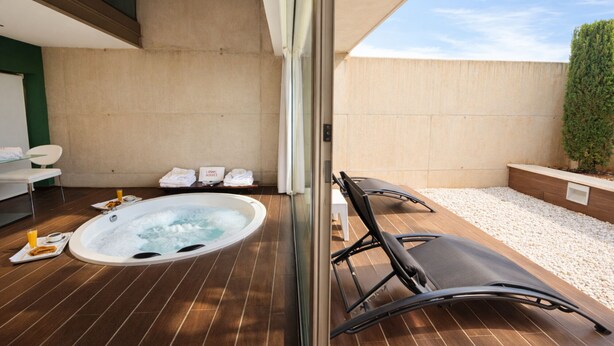 Zona de spa con hidromasaje, sillones reclinables y toallas.