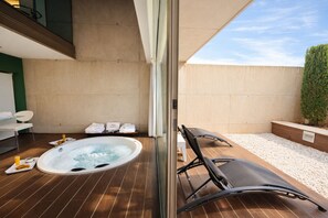 A spa area with a hot tub, lounge chairs, and towels.
