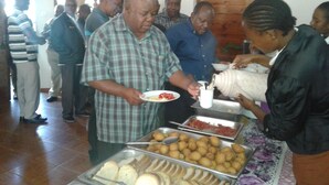 A buffet with various food items and people serving themselves. - St. Eugene's Hostel (Lushoto)