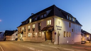 A traditional building with a sign reading "Landhaus Trunk". It features a symmetrical facade with multiple windows, a central entrance, and a staircase leading to the entrance. - Landhotel Traube (Konstanz)