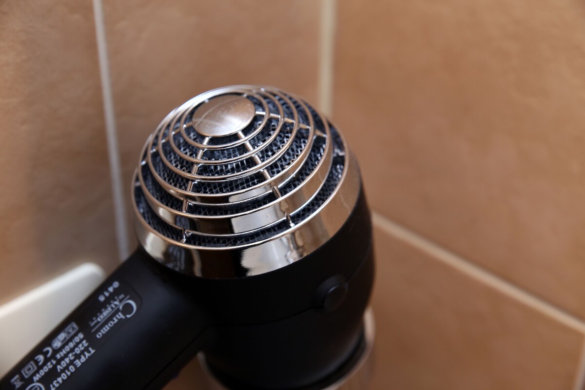 A black portable heater with a metallic top and a control panel.