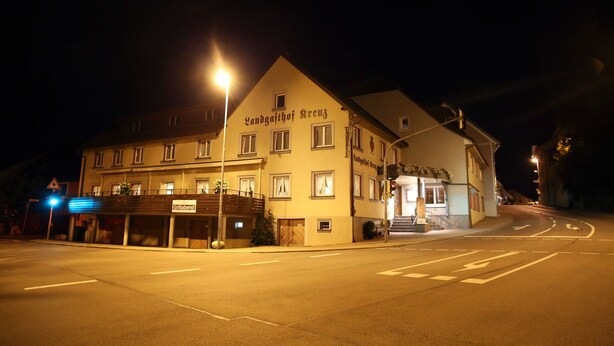 Ein Gebäude mit einem Schild, auf dem 'Landgasthof Kreuz' und 'Grillabend' steht.