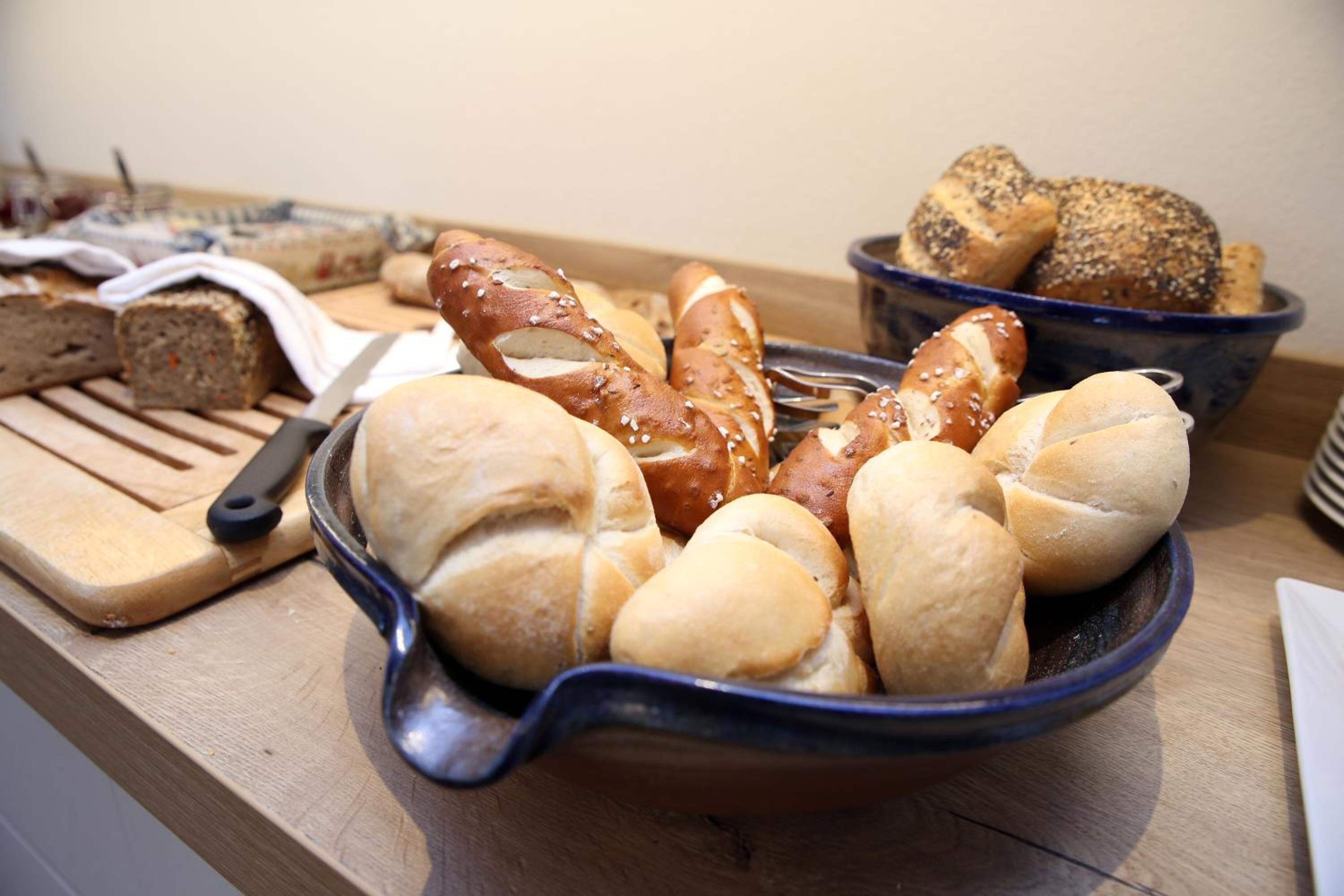 Une variété de pains et de petits pains disposés sur une table en bois.