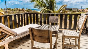 A wooden deck with a lounge chair, a dining table, and chairs. - Ocean View Villas Bonaire (Kralendijk)