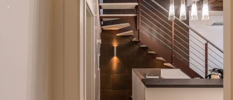 A modern staircase with a wooden finish and a metal railing.