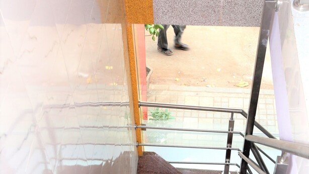 A staircase with a handrail leading to an outdoor area. - Delta Dormitory - Hostel (Mumbai)