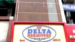 A building with a sign for 'DD Delta Dormitory' indicating a hostel or dormitory accommodation.