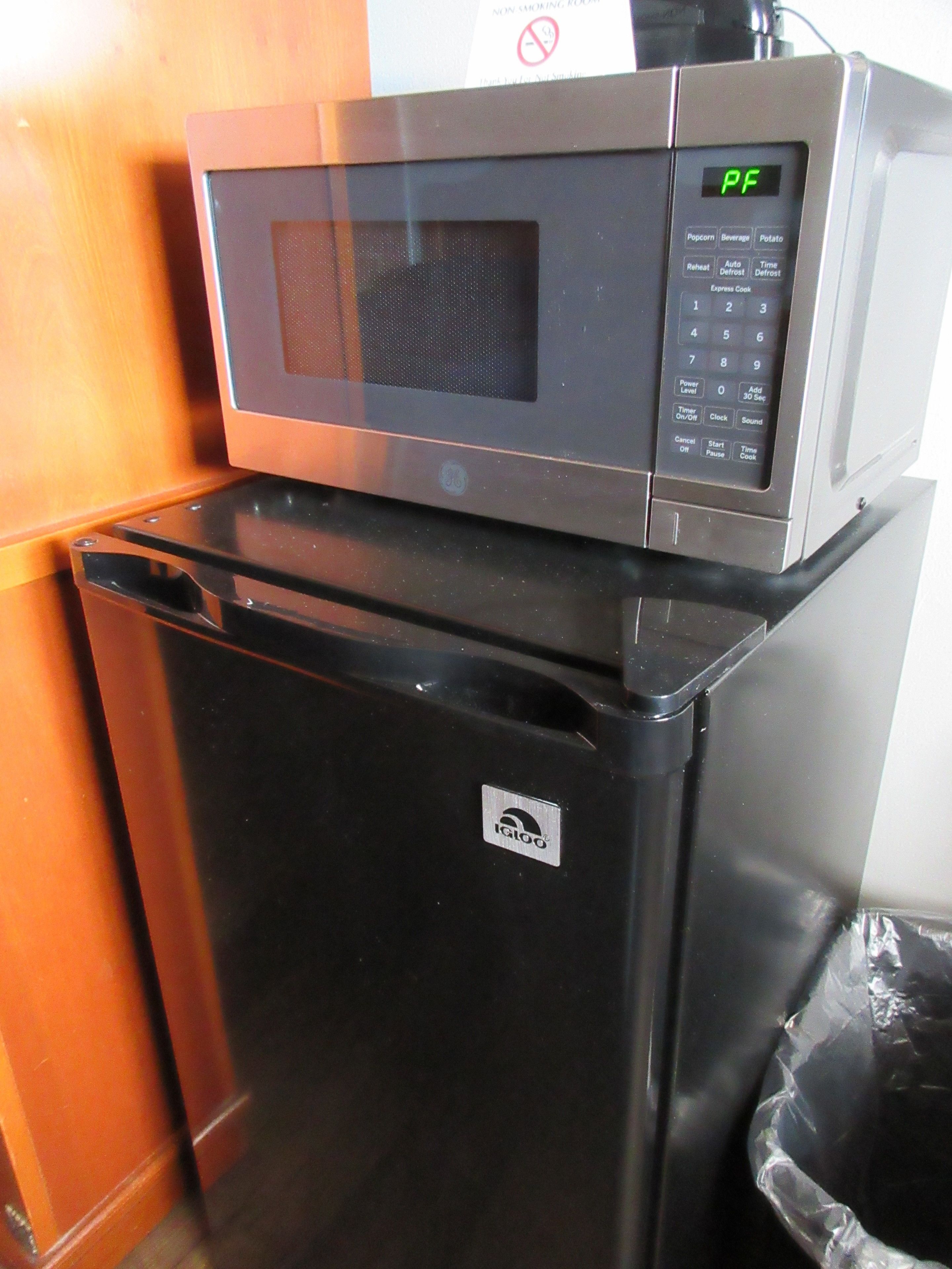 A compact kitchen with a microwave and a refrigerator.