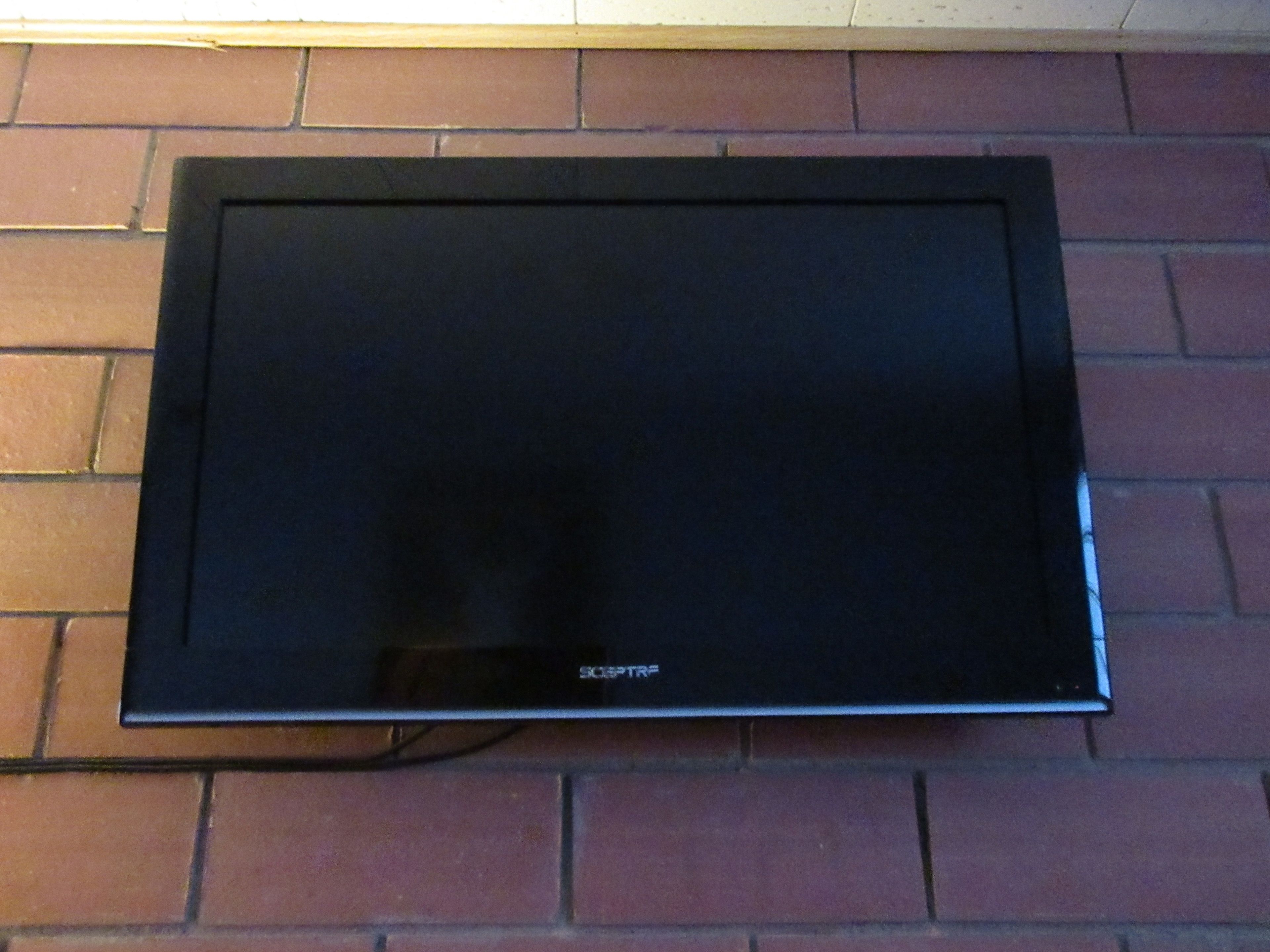 A flat-screen television mounted on a brick wall.