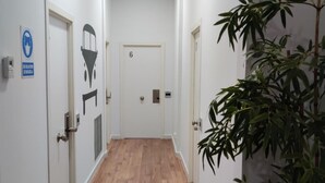 Ein Flur mit weißen Wänden, Holzdielen und Türen mit den Nummern 6 und 1.