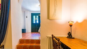 A hallway with a wooden bench, a radiator, and a wall-mounted lamp. - Cortijo el Indiviso (Barbate)
