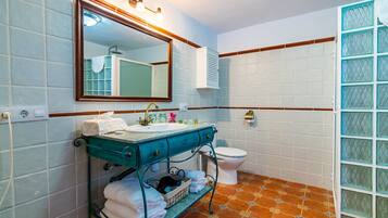 Un baño con lavamanos, espejo e inodoro.