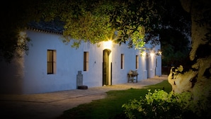 A white building with a tiled roof, a central door, and multiple windows. - Cortijo el Indiviso (Barbate)