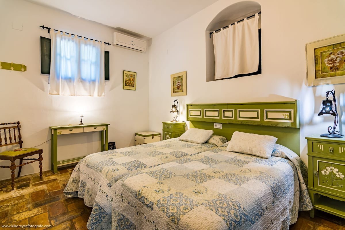 A bedroom with a bed, a desk, a chair, and a dresser.