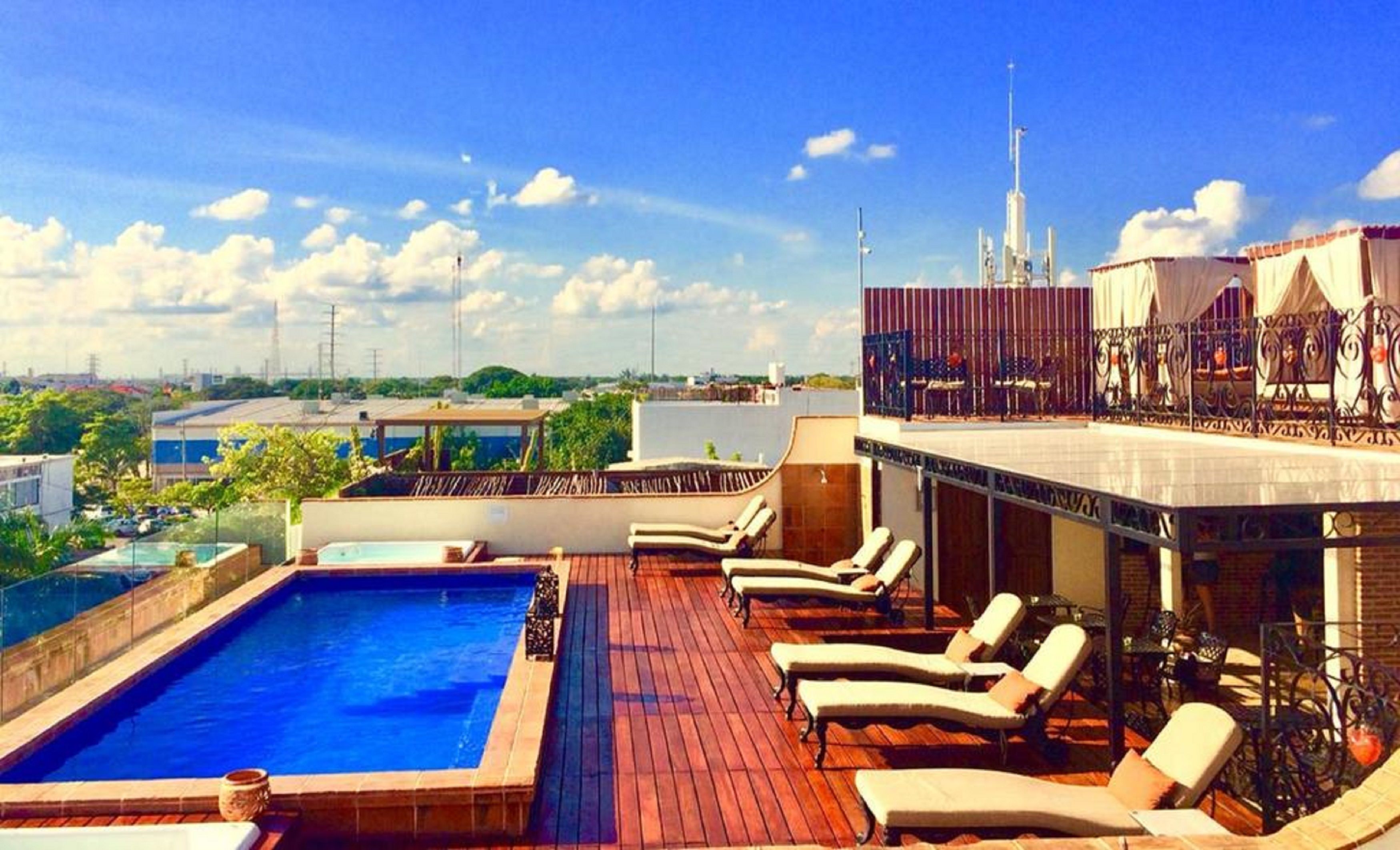 Una piscina en la azotea con vistas al horizonte de la ciudad, incluyendo un edificio alto con aguja.