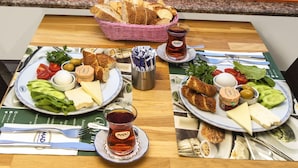 A table with a meal set and a view of a harbor with boats. - Mom Hotel (Adalar)