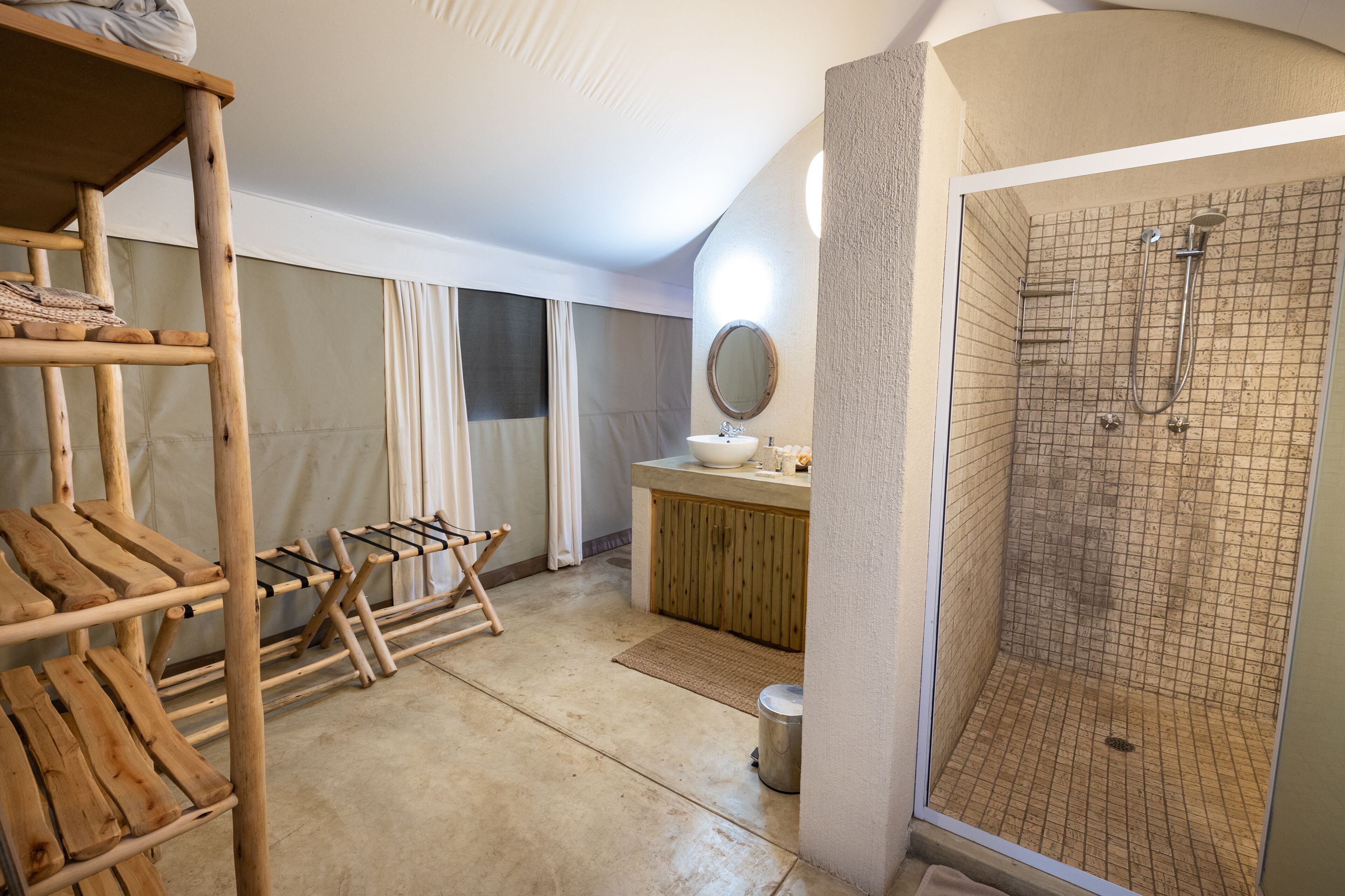 Une pièce avec des lits superposés, une douche, un lavabo et un miroir.