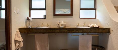 A bathroom with a double sink, two mirrors, and a towel rack.