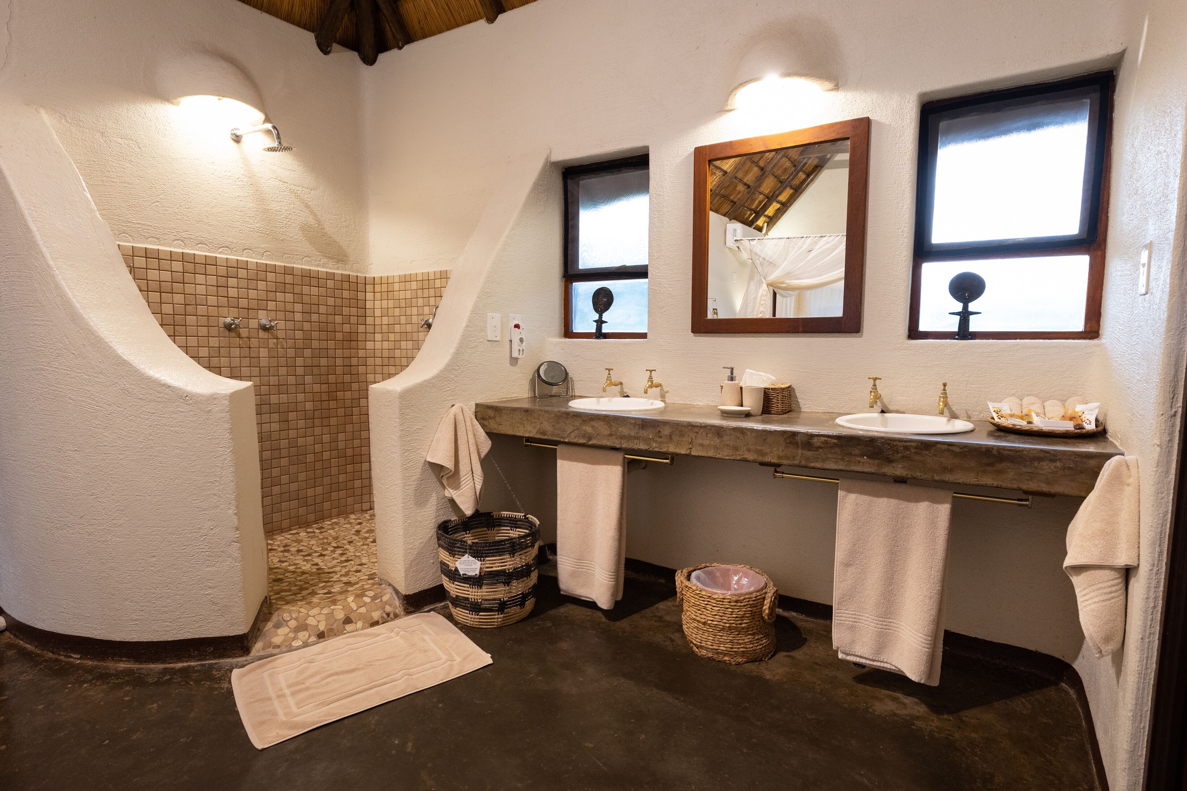 Un baño con bañera, dos lavamanos y un espejo grande.
