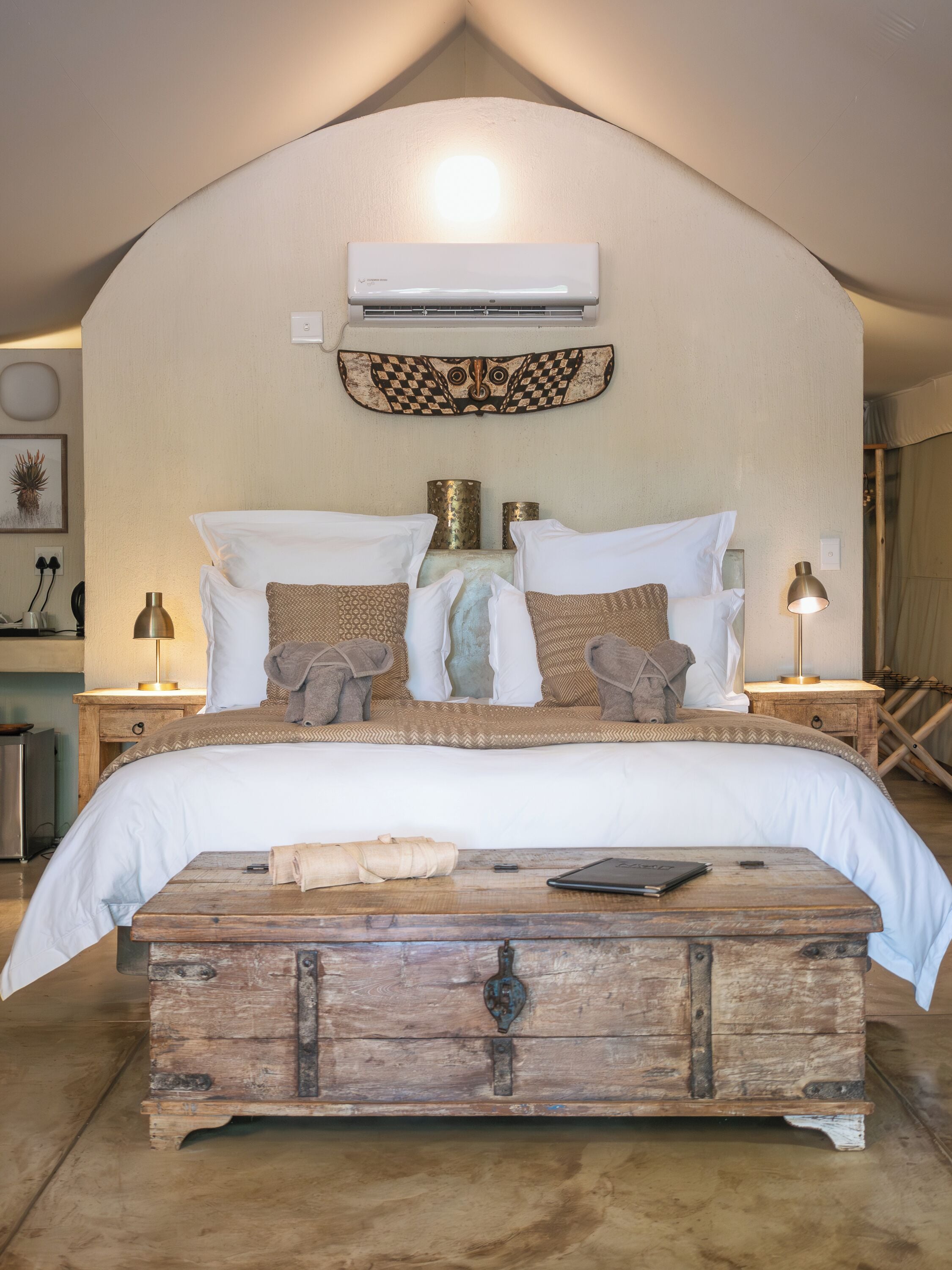 Ein Schlafzimmer mit einem großen Bett, einer Holzablage und einer Klimaanlage an der Wand.