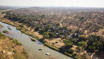 A river flowing through a rural area with scattered houses and sparse vegetation.