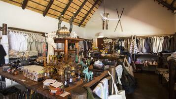 A rustic shop with wooden shelves filled with various items, including clothing and decorative objects.