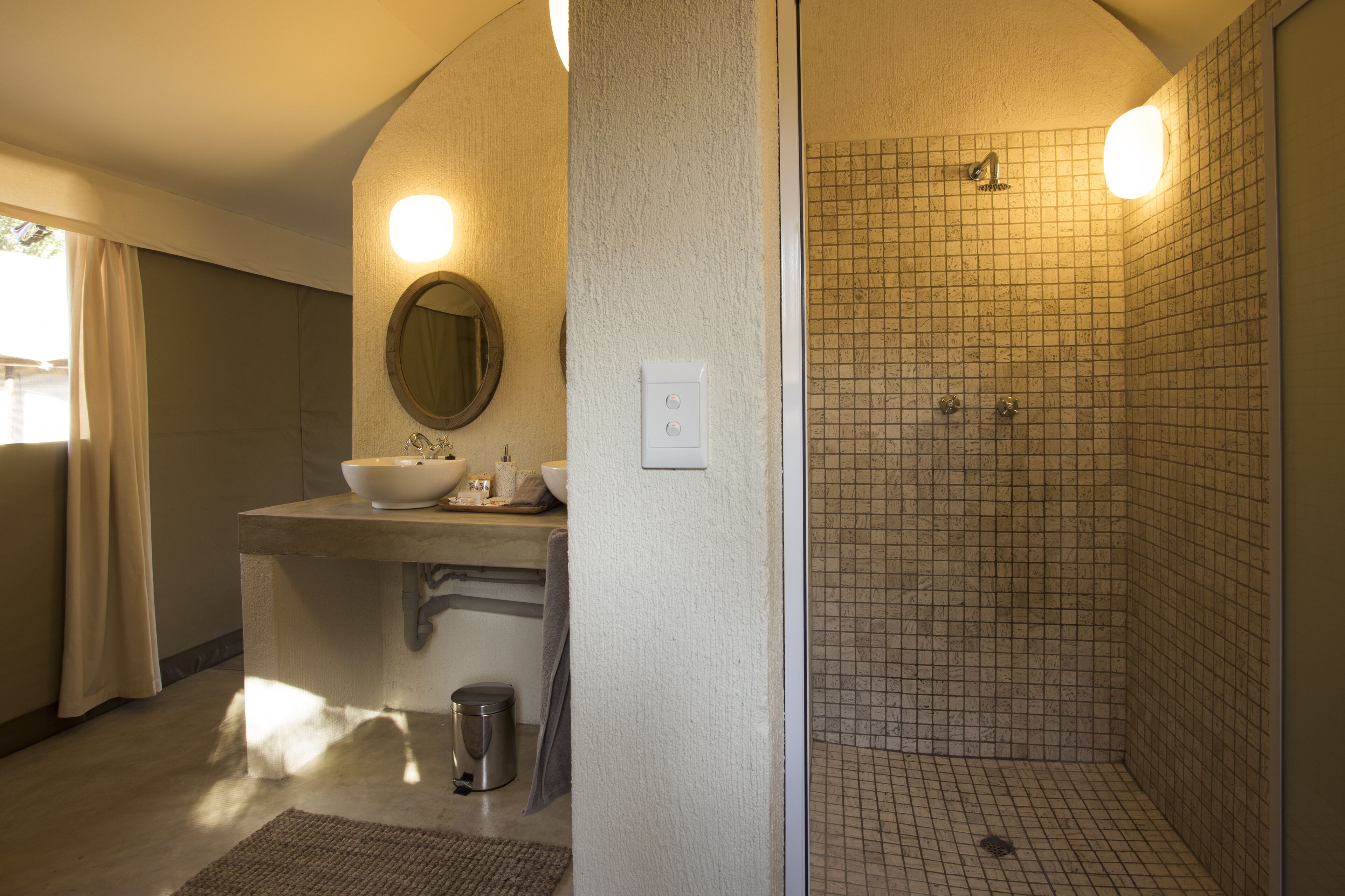 A bathroom with a sink, mirror, and shower.