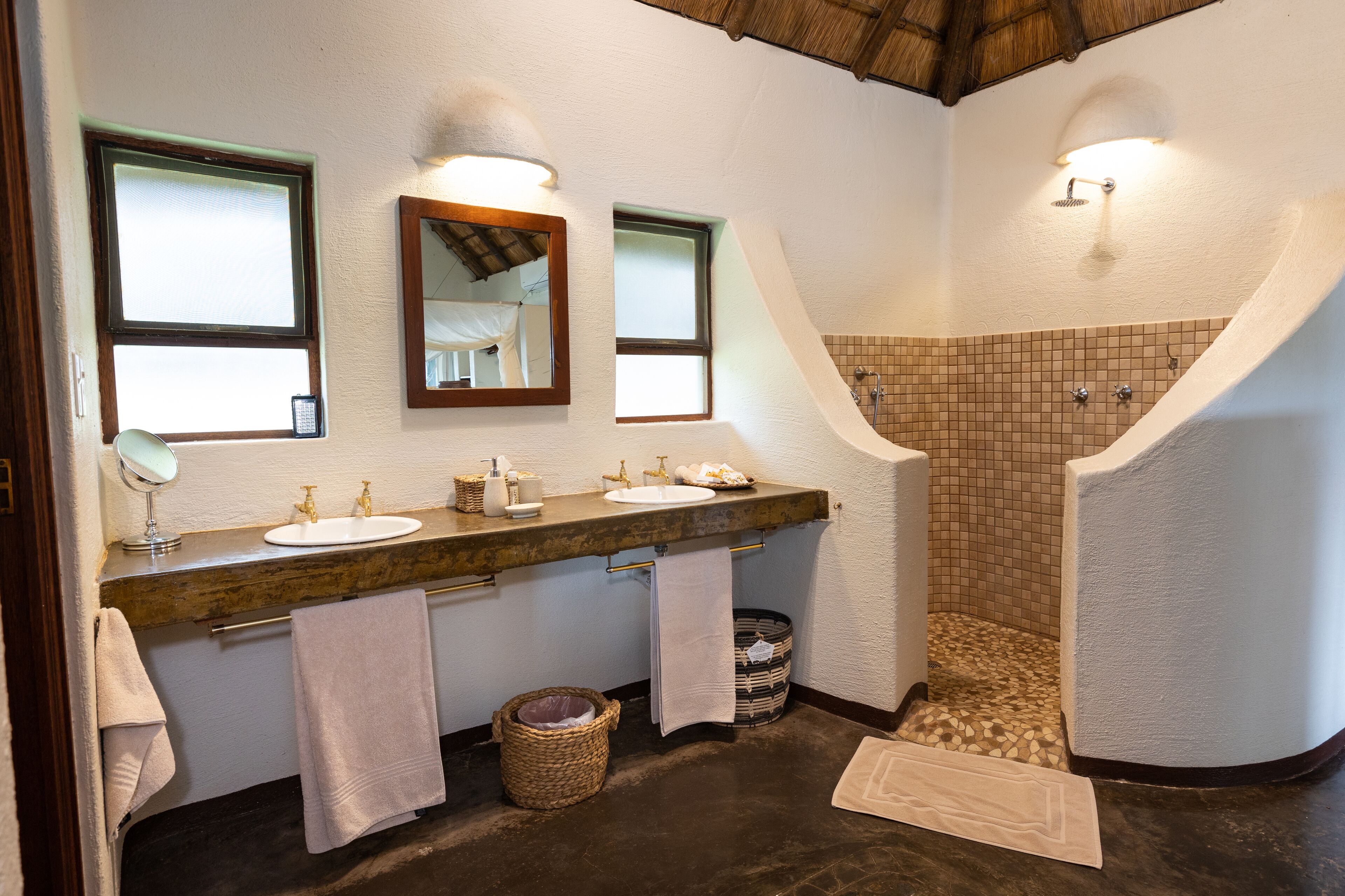 Un baño con dos lavamanos, un espejo y cabina de ducha.