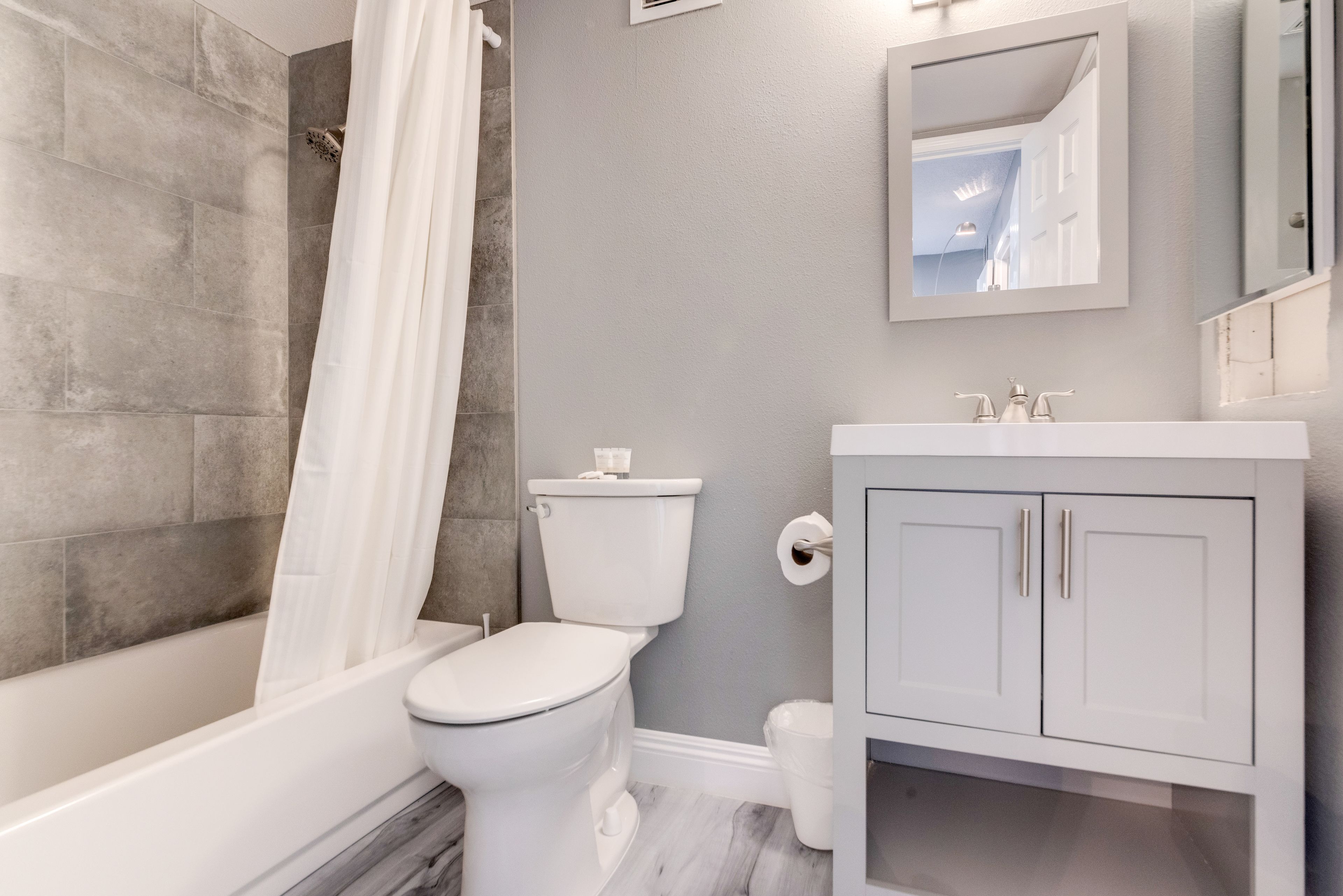Une salle de bain moderne équipée d’une baignoire, de toilettes et d’un meuble-lavabo.